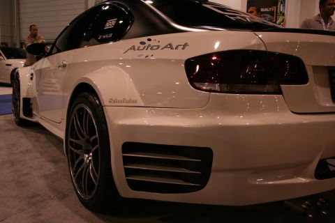 1998 Ford Crown Victoria - A white custom coupe with aftermarket body modifications is displayed indoors, unique fender flares and rear bumper vents.