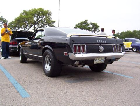 1970 Ford Mustang - Rear view of a black 1970 Ford Mustang with other cars in the background.