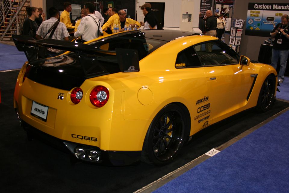 Yellow Nissan GT-R with black spoiler and accents, custom badging on side and rear