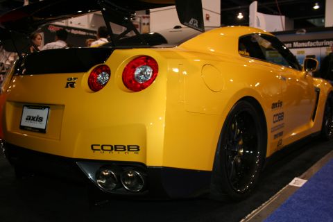 1998 Ford Crown Victoria - Rear view of a yellow Nissan GT-R at a car show, aftermarket tuning parts.