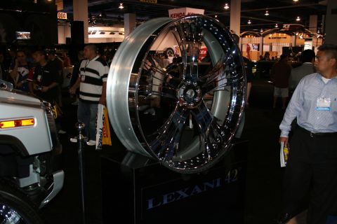 Chrome Lexani 42 custom wheel on display stand, with a white vehicle part visible to the left