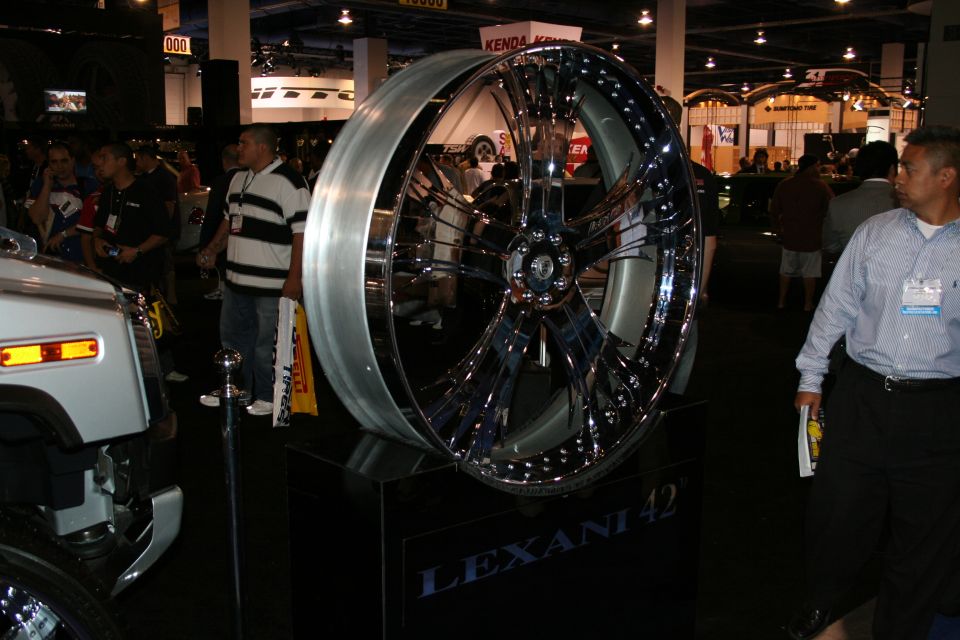 Chrome Lexani 42 custom wheel on display stand, with a white vehicle part visible to the left