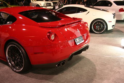 Red sports car rear view with dual exhaust and custom wheels