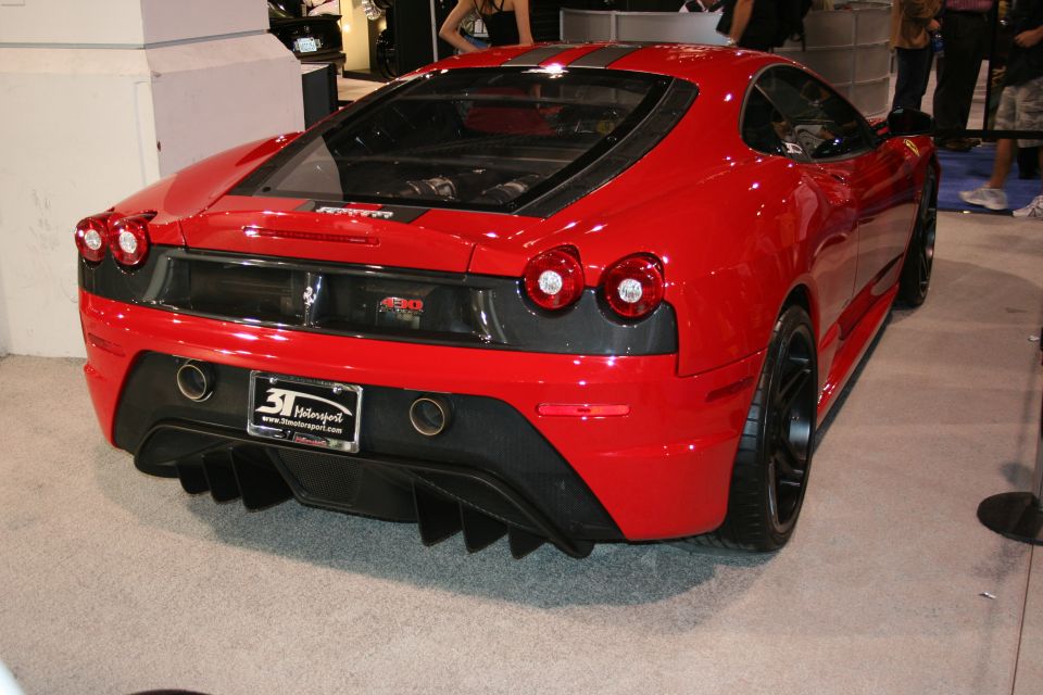 Red Ferrari F430 Scuderia rear view with quad exhaust and diffuser. License plate reads 31 Motorsports