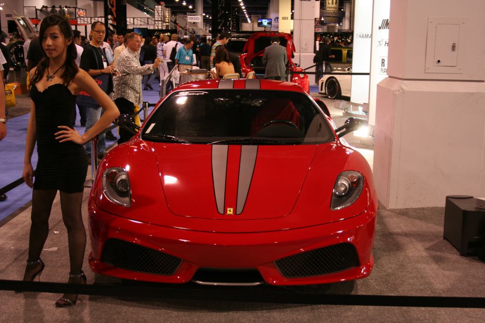 Red sports car with silver racing stripes on the hood, front view