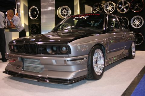 Modified BMW E30 M3 with custom front bumper and carbon fiber hood