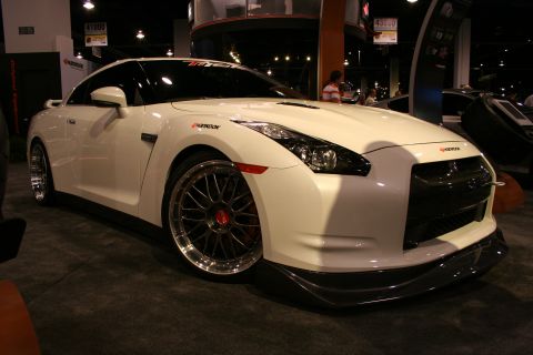 White Nissan GT-R with custom wheels and body kit, angled front-right