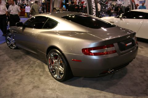 Gray Aston Martin DB9 coupe rear 3/4 view, showing chrome wheels and Hankook tire branding on the rear