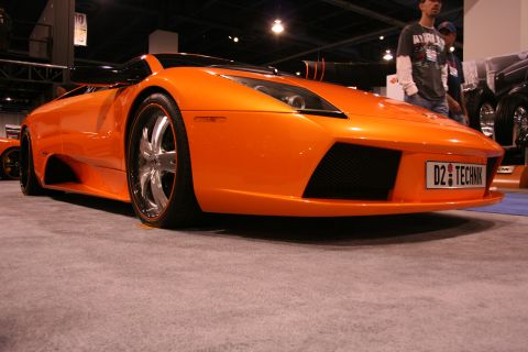 Orange sports car with custom license plate 'D2 TECHNIK' and chrome wheels