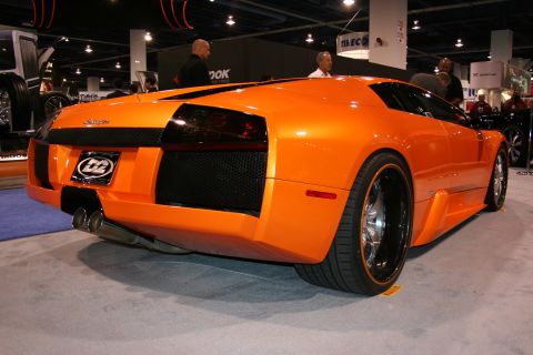 Orange sports car rear view with custom wheels and dual exhaust