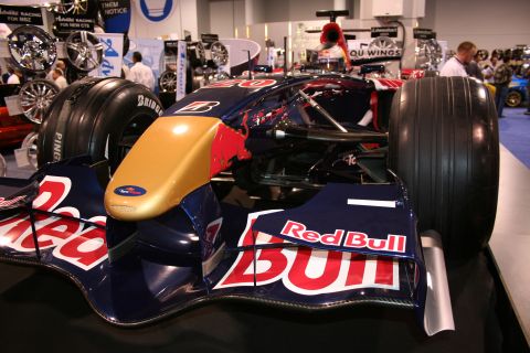 Front view of a Red Bull F1 car with gold nose cone and Red Bull logos