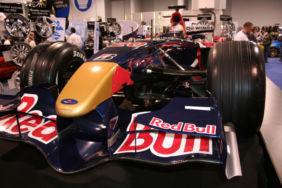 Front view of a Red Bull F1 car with gold nose cone and Red Bull logos
