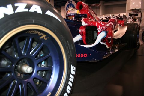 Close-up of a blue and red Formula 1 race car's front tire and bodywork