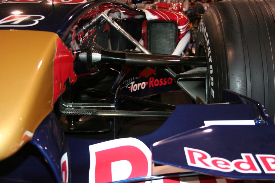 Close-up of a Scuderia Toro Rosso F1 car's front wheel and bodywork, showing Red Bull logos