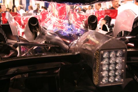 Race car rear view with dual exhaust pipes and a cluster of LED lights on a housing