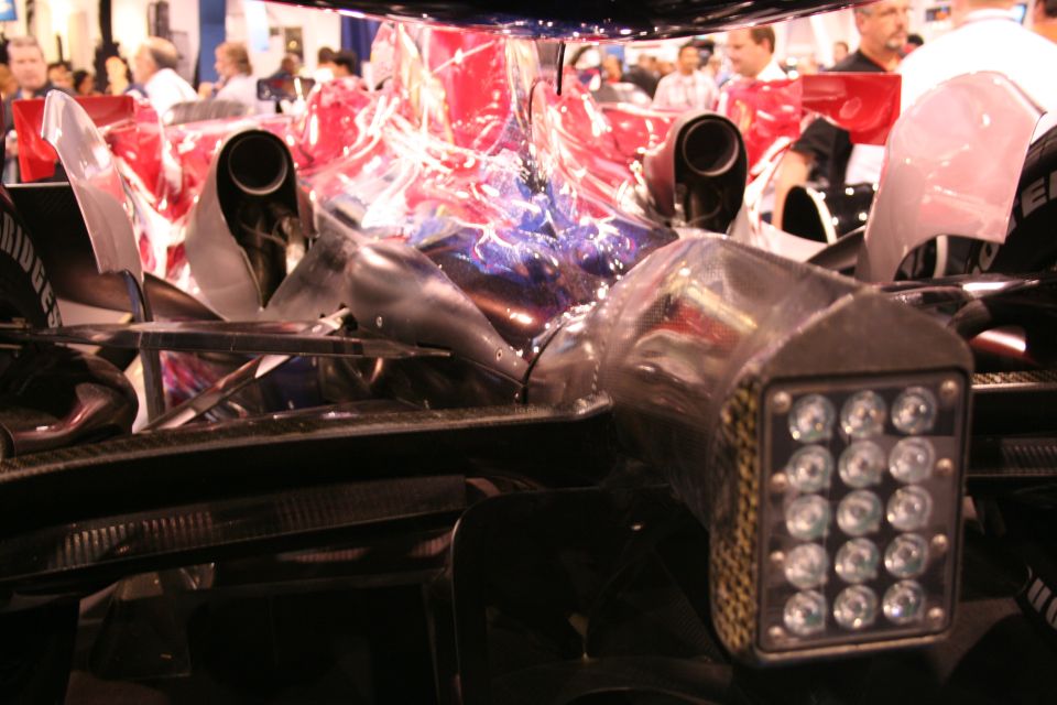 Race car rear view with dual exhaust pipes and a cluster of LED lights on a housing
