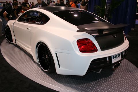 White Bentley Continental GT with black accents and custom body kit on display