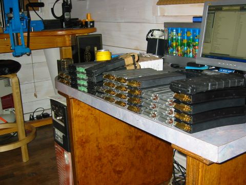 1996 Ford Bronco - Numerous loaded ammunition magazines are neatly stacked on a desk next to a computer and other equipment.