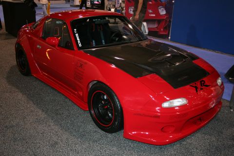 Red sports car with black carbon fiber hood and custom body kit