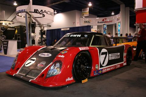 Red and black number 7 BMW endurance race car at an auto show booth