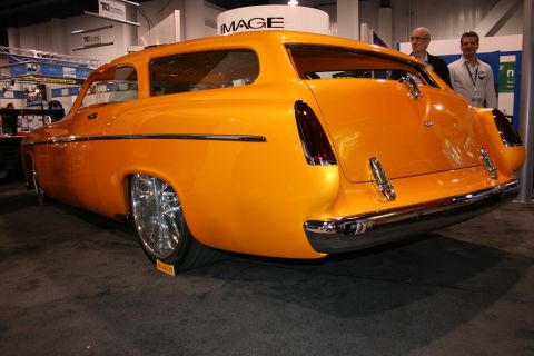 Rear view of an orange custom wagon hot rod at an auto show