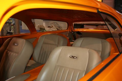 Tan leather bucket seats inside a custom orange show car