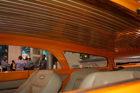Wood-slat headliner and tan seats inside a custom orange show car
