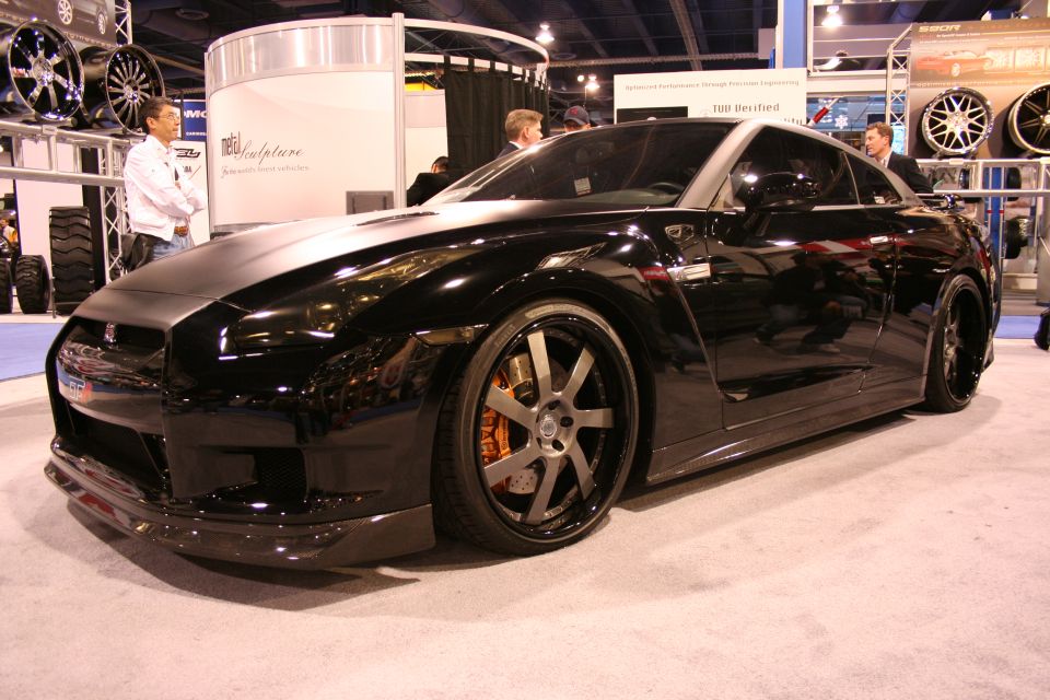 Black Nissan GT-R front three-quarter view at an auto show booth