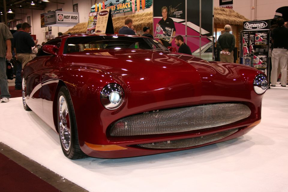 Dark red custom streamliner car front view at a trade show