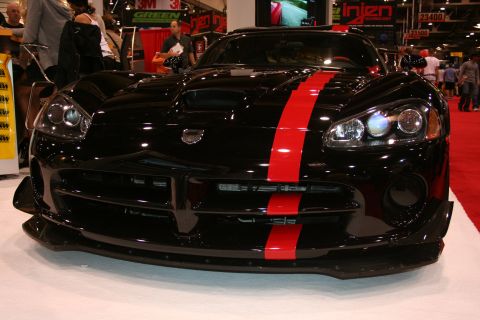 Black Dodge Viper with red stripe front view at a trade show