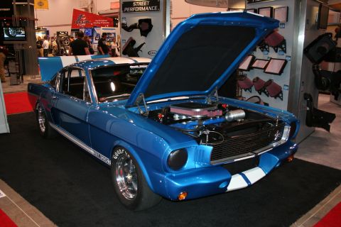 Blue Shelby Mustang fastback with open hood at trade show