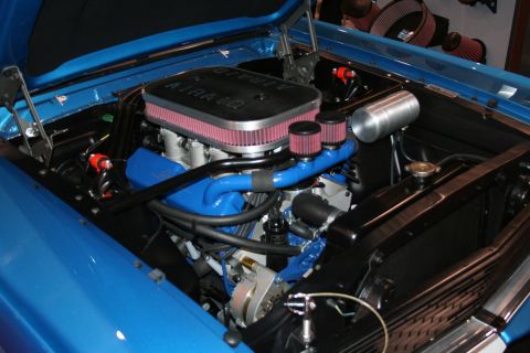Engine bay of blue Mustang with dual air cleaners
