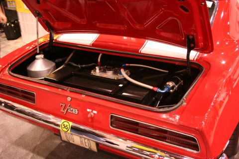 Open trunk of a red Camaro Z/28 'Big Red' showing fuel cell and plumbing