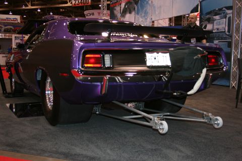 Purple Plymouth Cuda drag car with wheelie bars, rear view