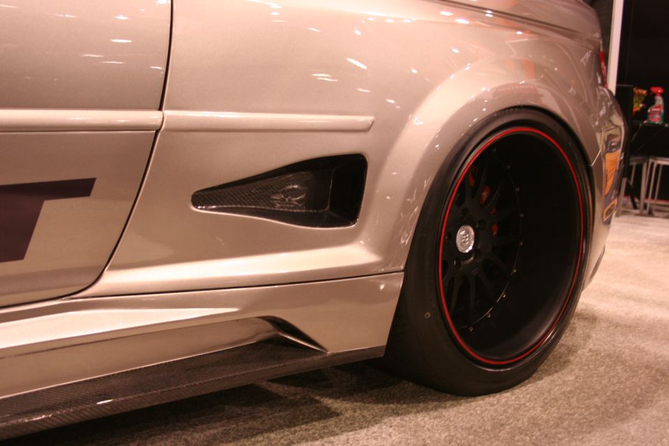Close-up of widebody car fender, side vent and black wheel