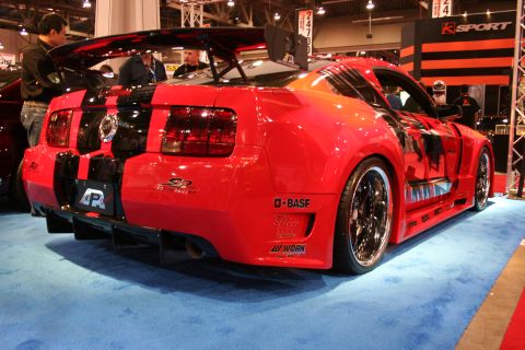 Red and black widebody Ford Mustang, rear three-quarter view