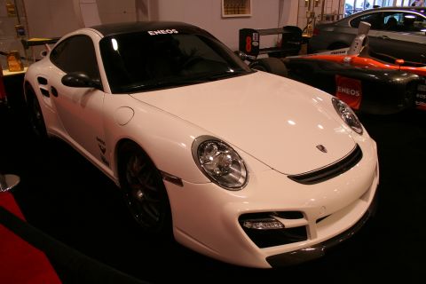 White Porsche 911 Turbo with ENEOS livery on a show floor