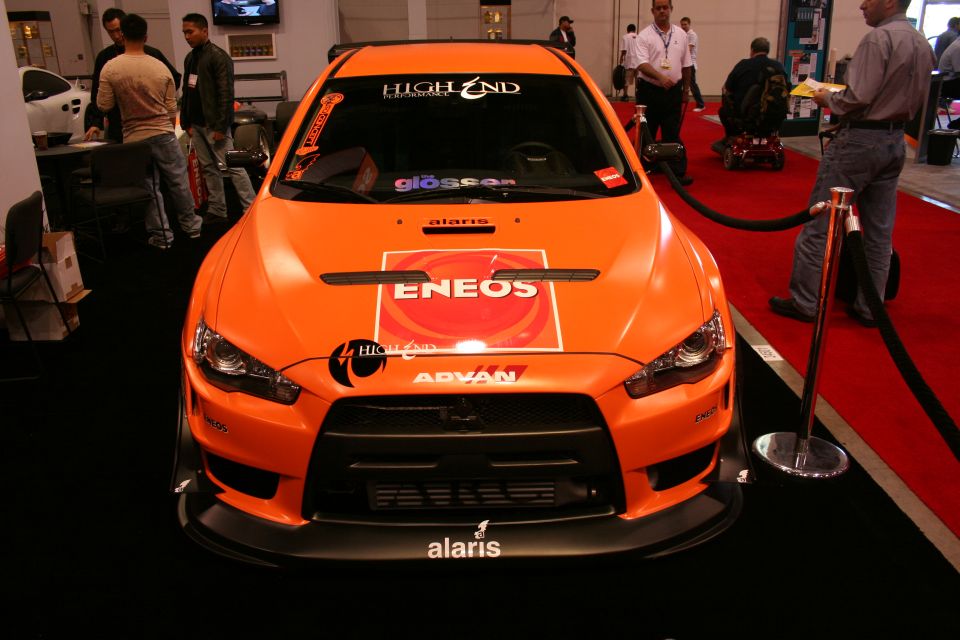 Orange ENEOS-liveried Mitsubishi Lancer Evolution show car, front view