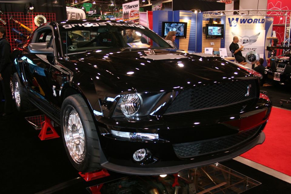 Black Shelby GT500 Mustang on a display ramp at an auto show