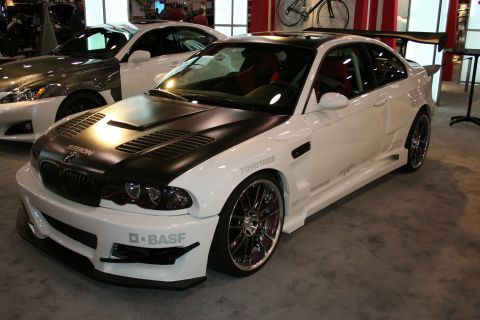White coupe with black hood and large rear spoiler, "D-BASF" on front bumper