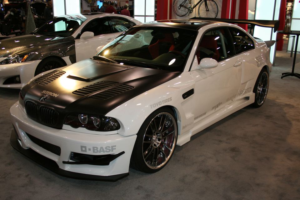 White coupe with black hood and large rear spoiler, "D-BASF" on front bumper