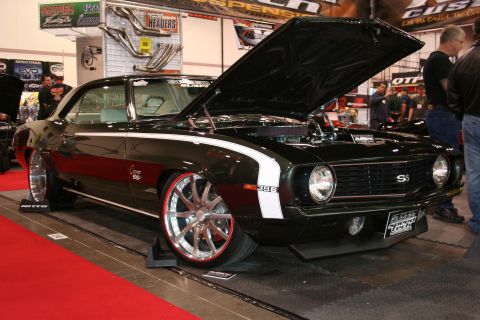 Black 1969 Chevrolet Camaro SS with white racing stripes and chrome wheels