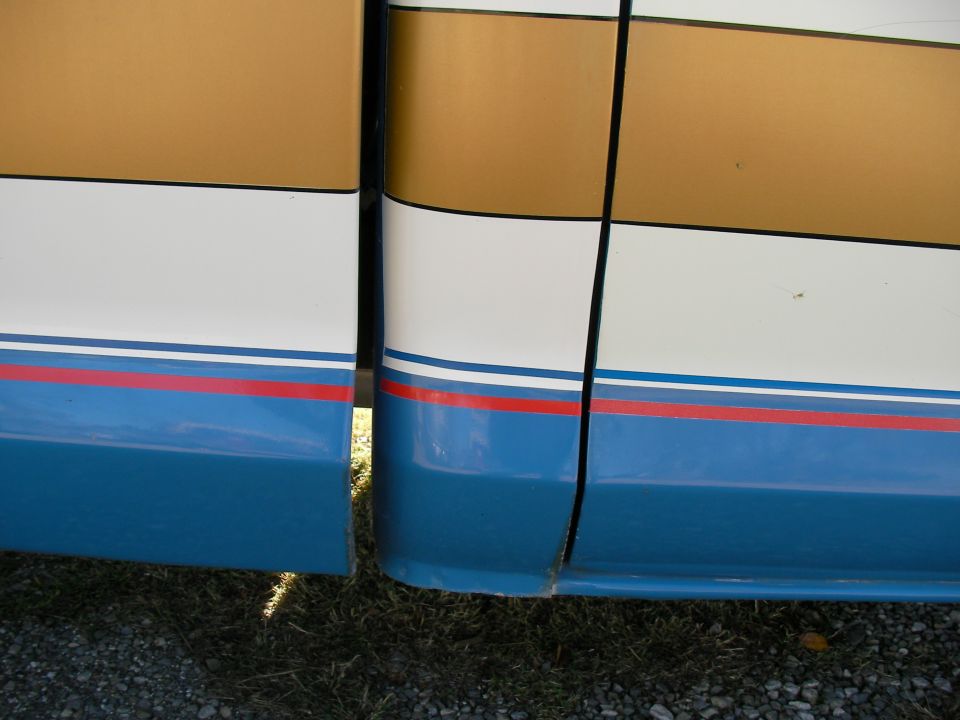 Side view of truck door seam with blue, white, and gold stripes