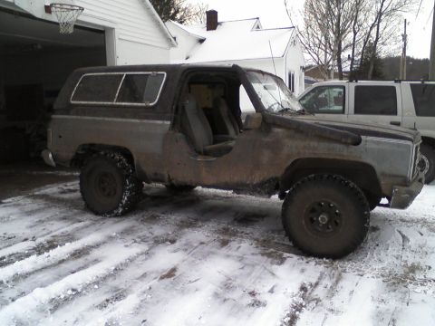 1988 Chevrolet Blazer - This weathered SUV, possibly modified for off-roading, sits in a snowy driveway next to another vehicle.