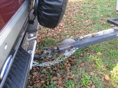 1996 Ford Bronco - Trailer hitch and safety chains connected to the rear of a vehicle.
