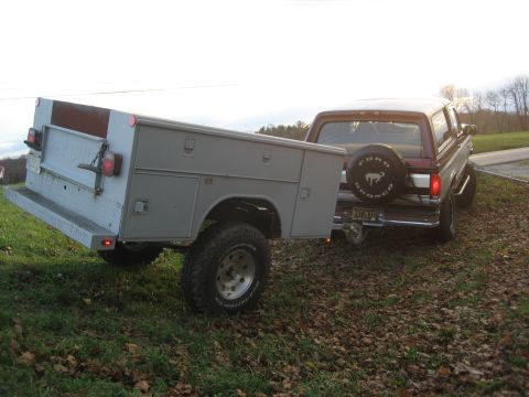 1996 Ford Bronco - This 1996 Ford Bronco is seen from the rear, towing a utility trailer with a spare tire mounted on the back.