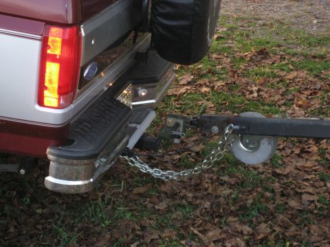 1996 Ford Bronco - Rear view of a maroon and silver Ford Bronco with a trailer hitch and safety chains connected.