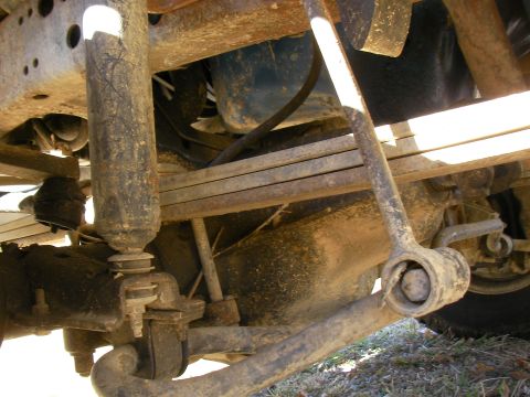 1979 Ford F-350 - Undercarriage view of a truck's suspension system, showing leaf springs and a shock absorber.