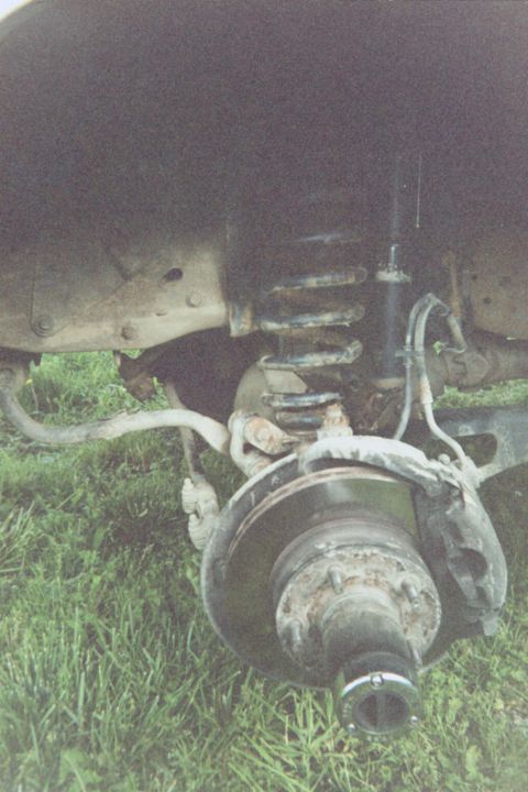 1995 Ford Bronco - Stock driver's side w/tire removed. The spring hook at the top of the spring is a 13mm (if memory serves) and comes off easily. The nut in…