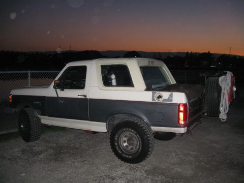 1991 Ford Bronco - This 1991 Ford Bronco is shown from the rear quarter angle, a two-tone paint scheme and a spare tire mounted externally.